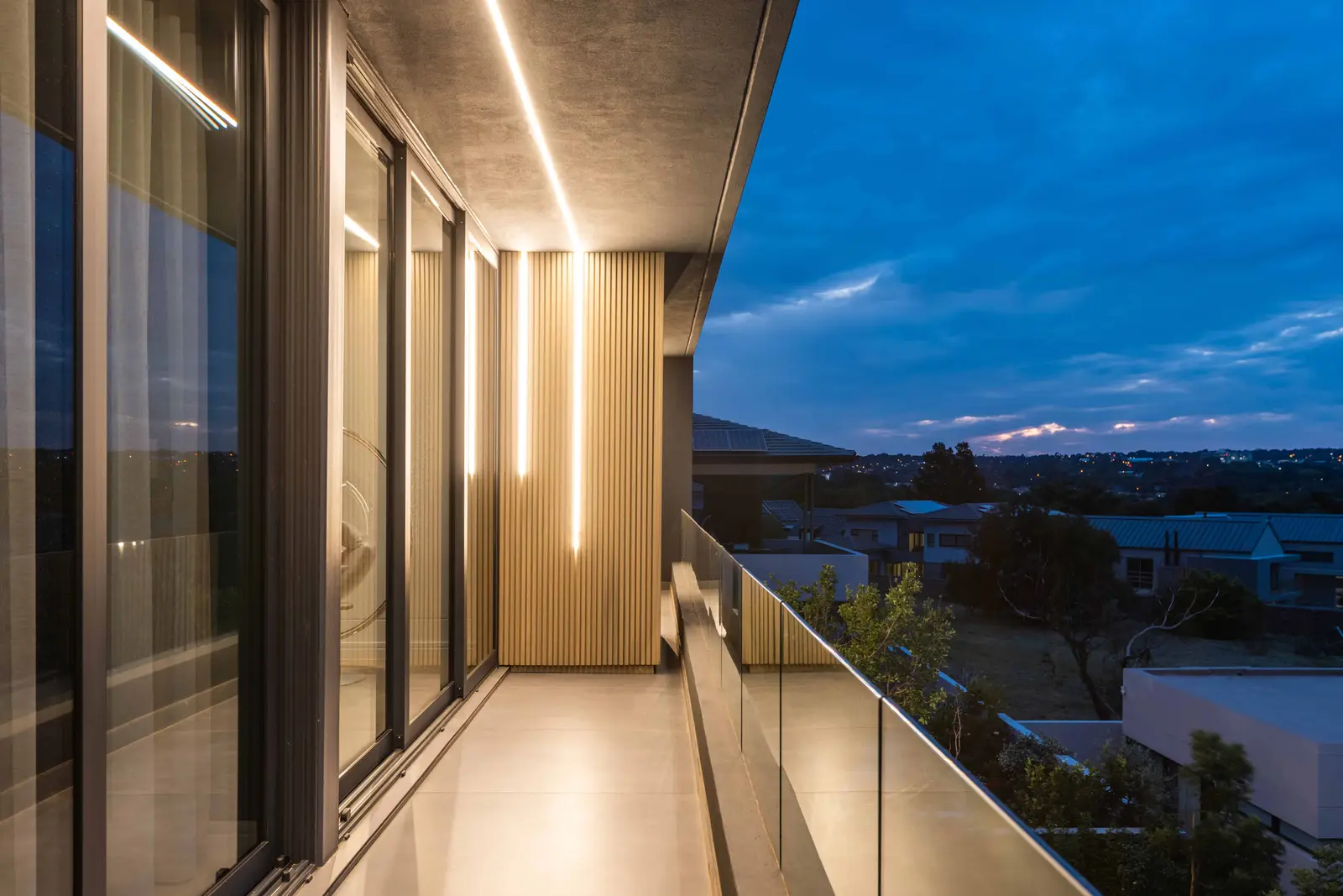 Balcony walkway with evening city views from a Steyn City luxury residence – Johannesburg interior designer Renovatio.