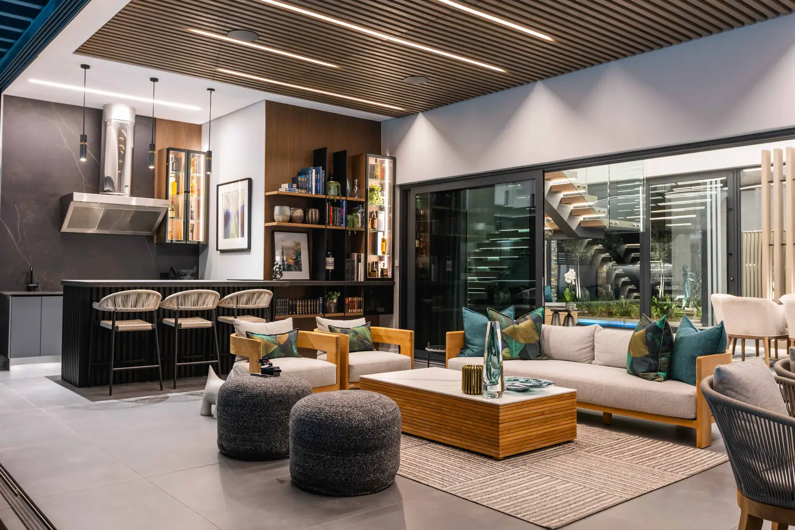 Luxury open-plan outdoor living space with glass façade connecting to patio, Steyn City residence – Renovatio Interiors Johannesburg.