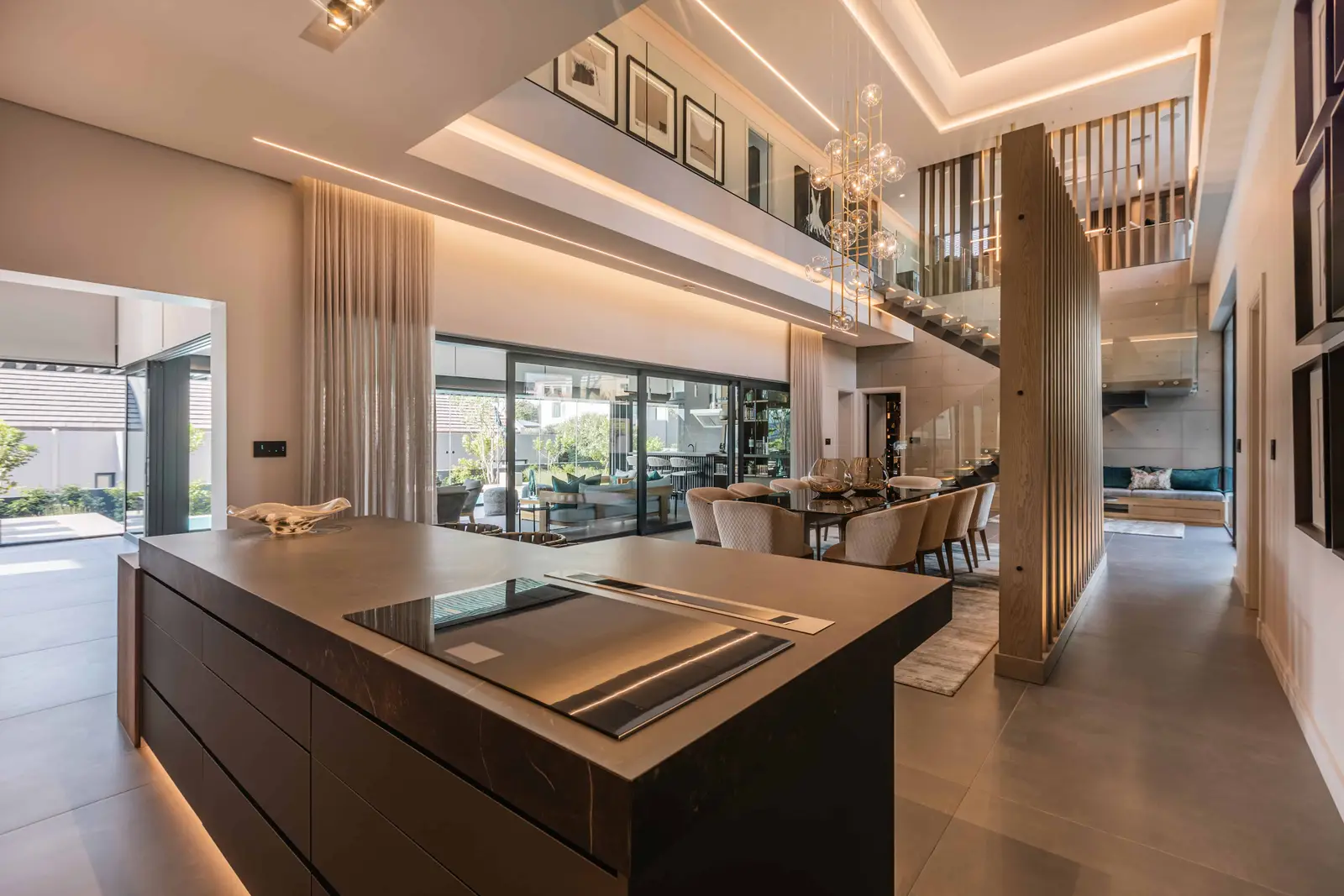 Open-plan living area with warm tones and double-volume windows in Steyn City home, Renovatio Interiors Johannesburg.