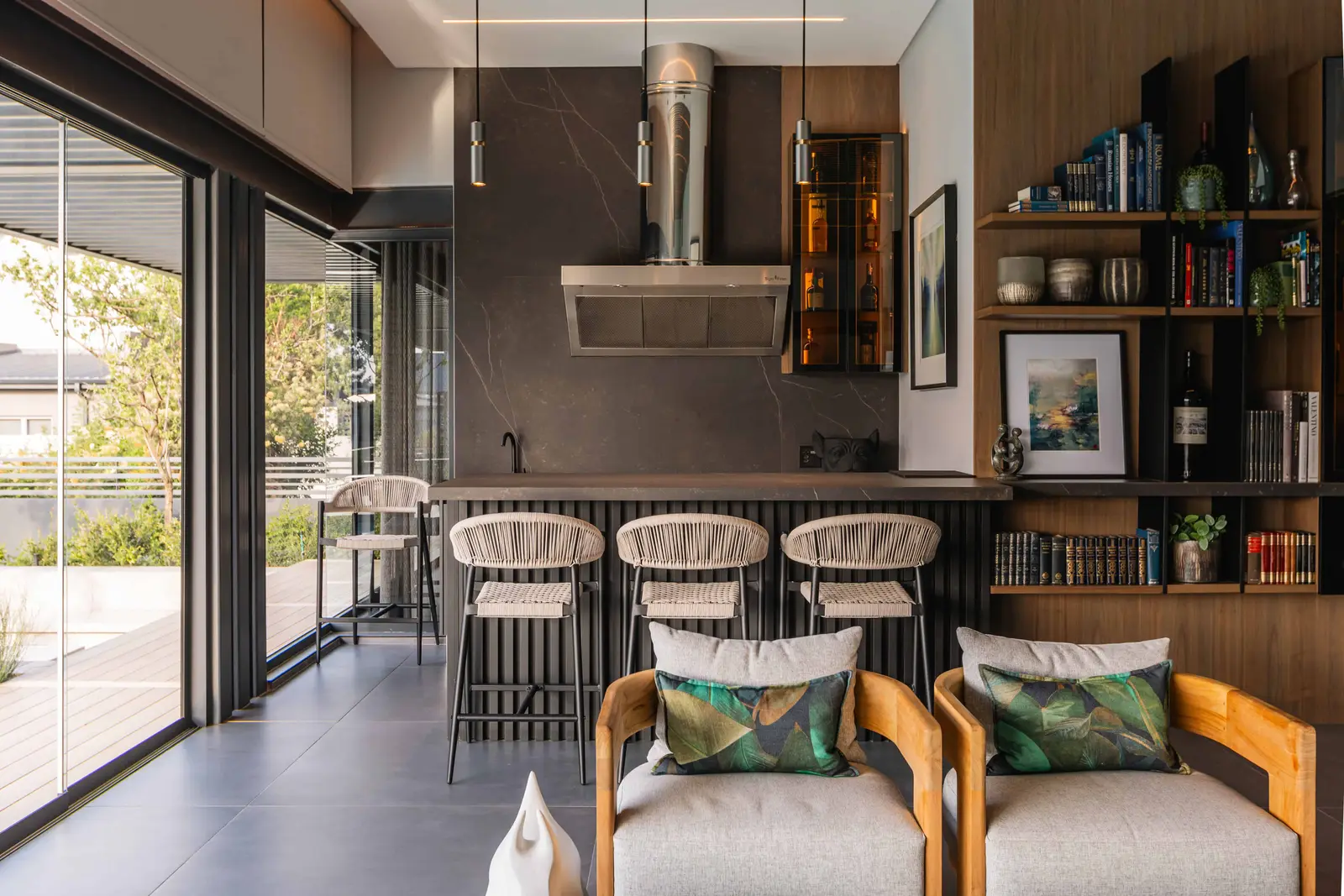 Contemporary bar and lounge area with built-in shelving in Steyn City luxury home by Renovatio Interiors Johannesburg.