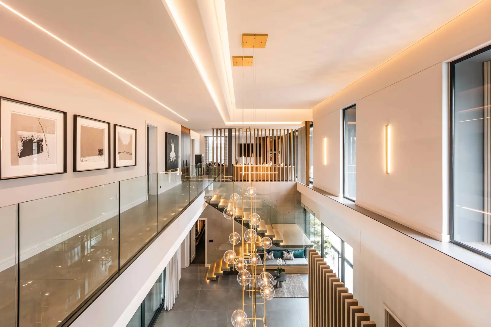 Long gallery corridor with cove lighting and framed artwork, Steyn City home – Renovatio Interiors.