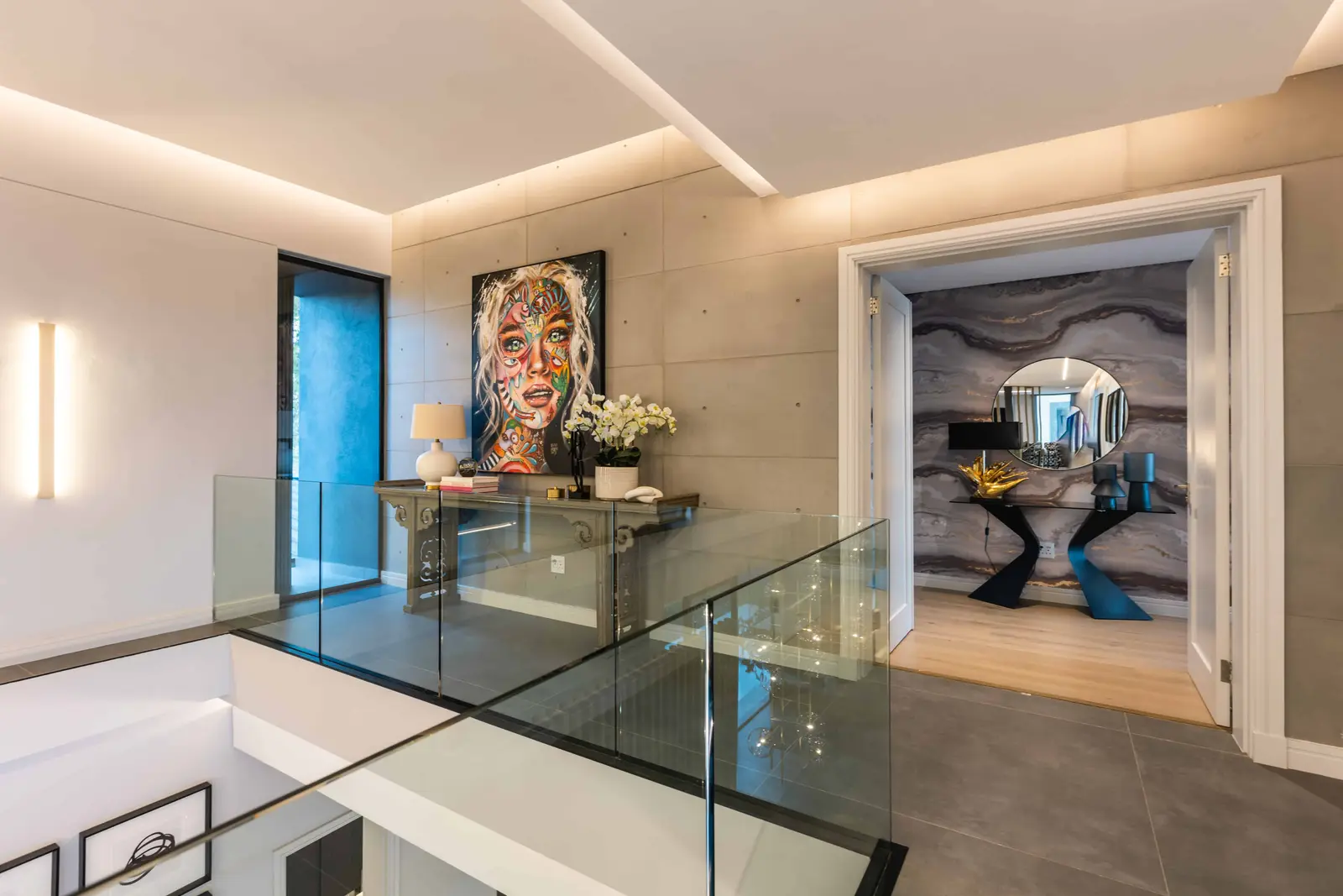 Minimalist passage with artwork and glass guardrail, Steyn City luxury residence – Renovatio.