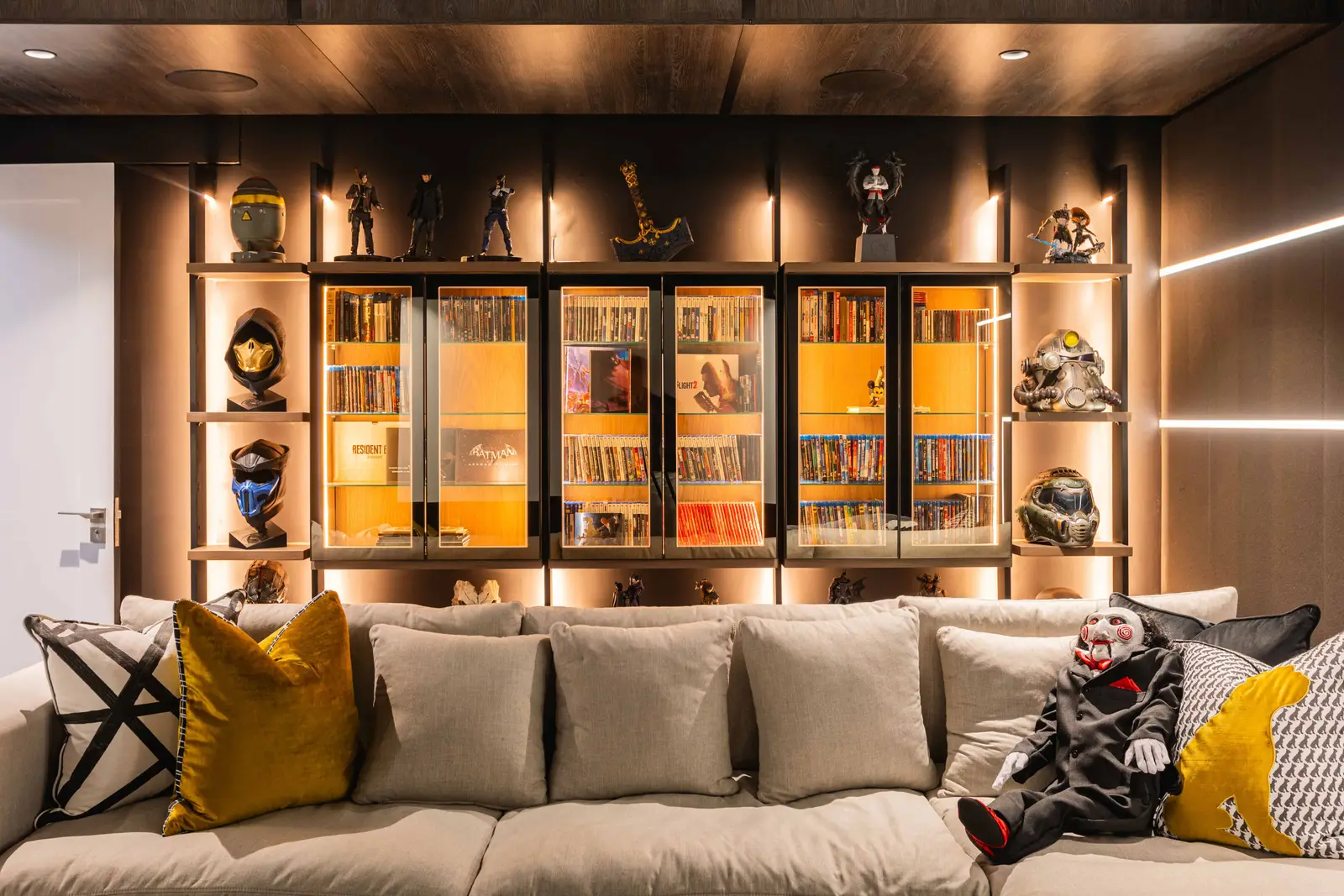 Cinema room with illuminated display cabinetry behind sofa, Steyn City luxury home – Johannesburg interior design.