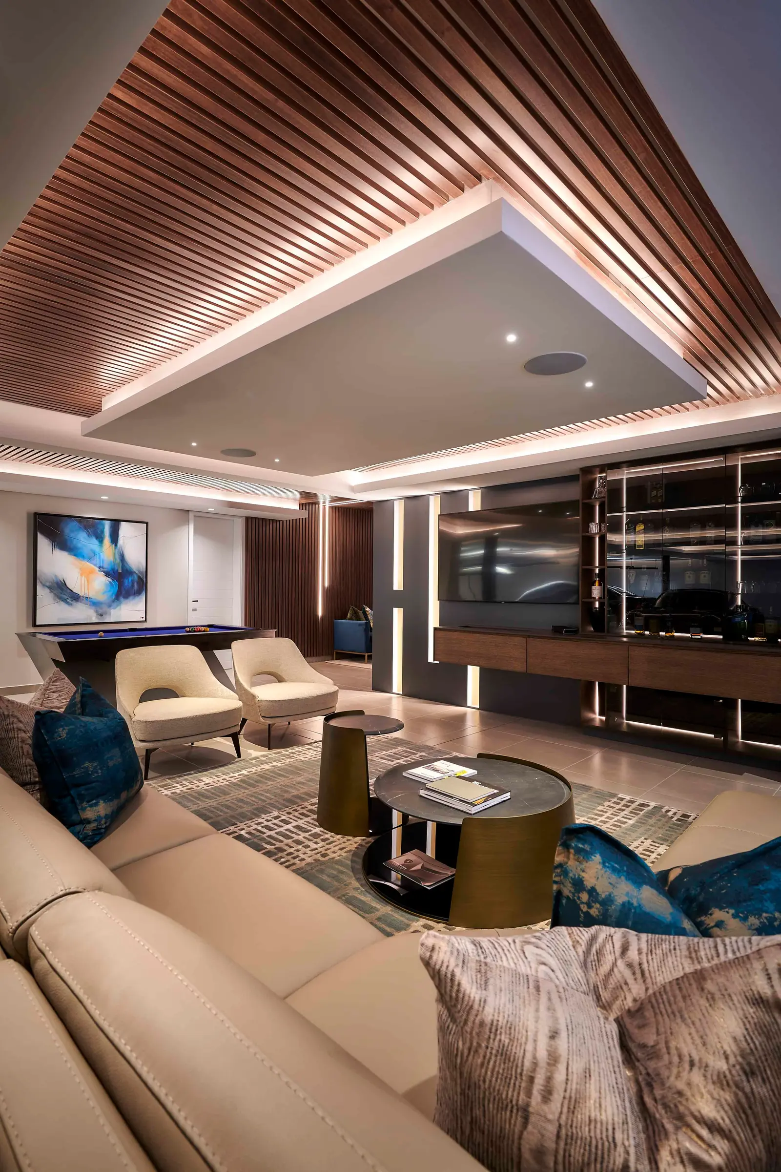 Open-plan entertainment area with vaulted ceiling, plush seating and feature wall designed by Interior Designer Johannesburg.