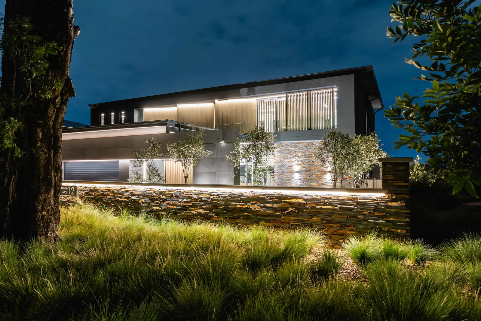 Modern Steyn City home exterior at dusk, surrounded by lush landscaping – Renovatio Interiors Johannesburg.