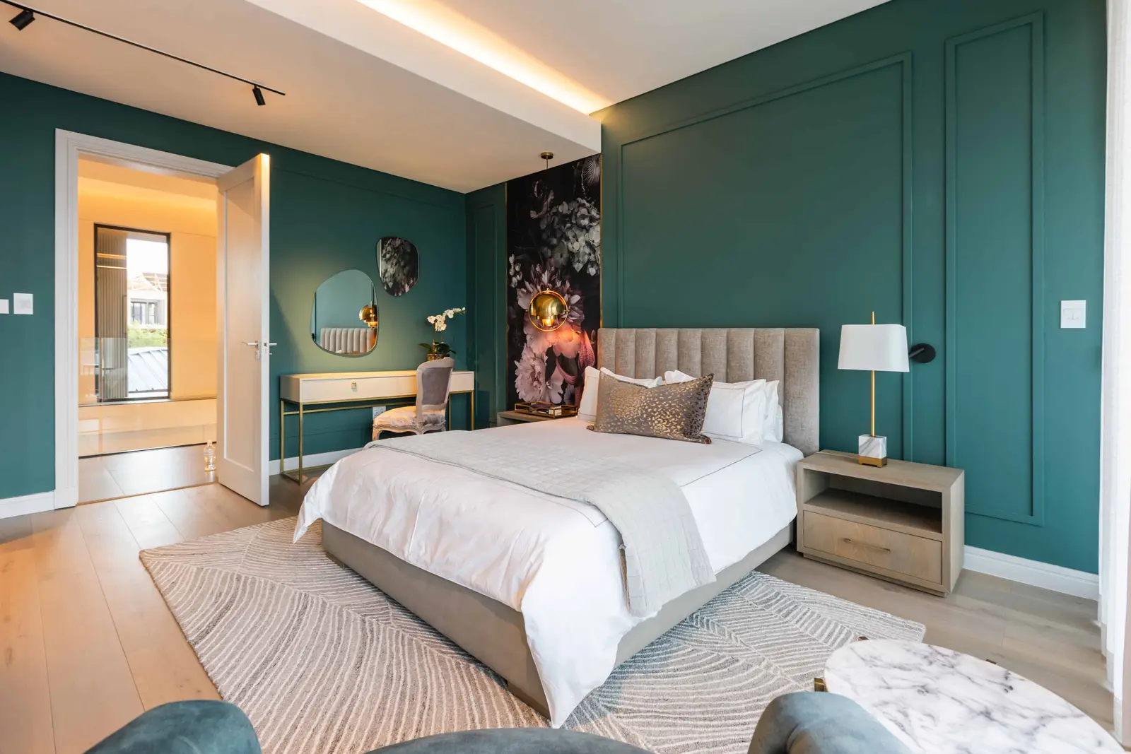 Sophisticated guest bedroom with soft teal feature wall and layered lighting in Steyn City – Renovatio Interiors Johannesburg.