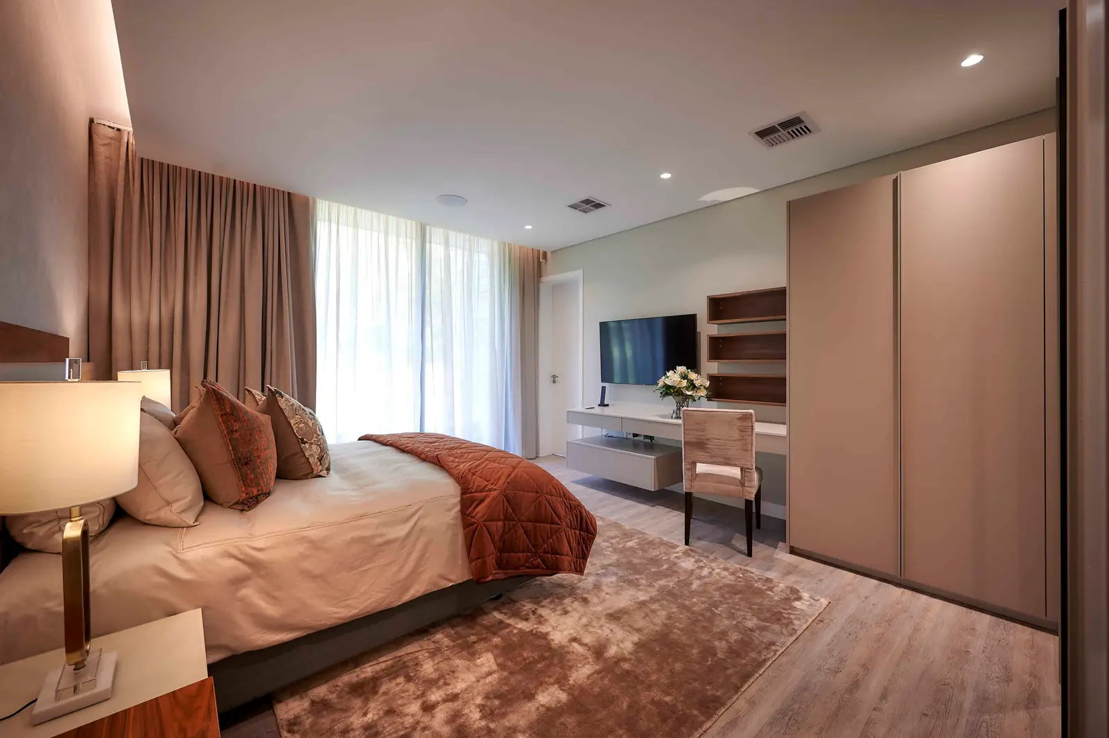 Modern bedroom with large windows, neutral tones and sleek furniture created by Interior Designer Johannesburg.