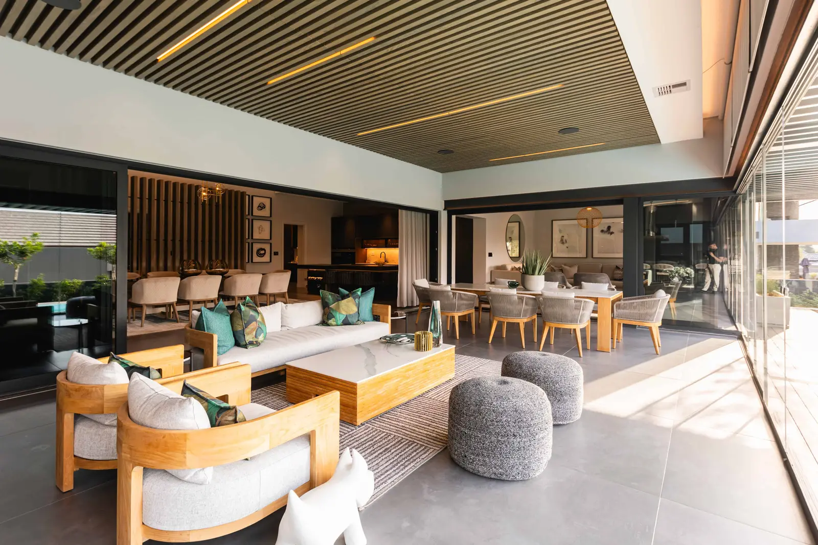 Open-plan outdoor living area with modern lounge furniture and pool view in Steyn City, designed by Renovatio Interiors Johannesburg.