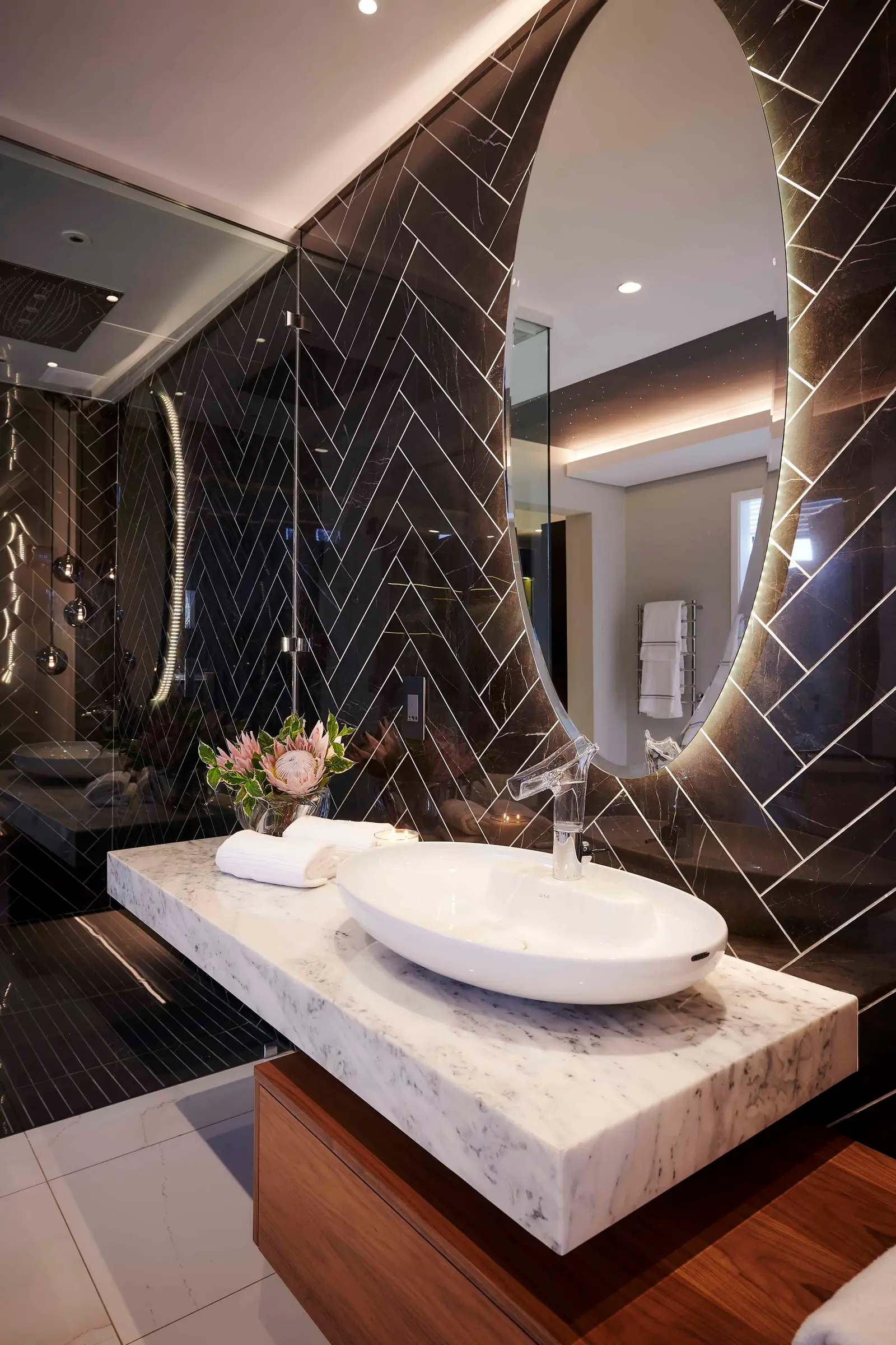 Luxurious bathroom vanity with vessel sink, dark tile backdrop and refined finishes by Interior Designer Johannesburg.