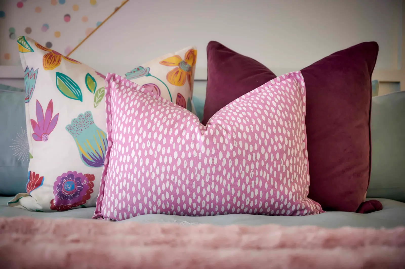 Detailed shot of colorful cushions and pillows on a bed with floral patterns styled by Interior Designer Johannesburg.