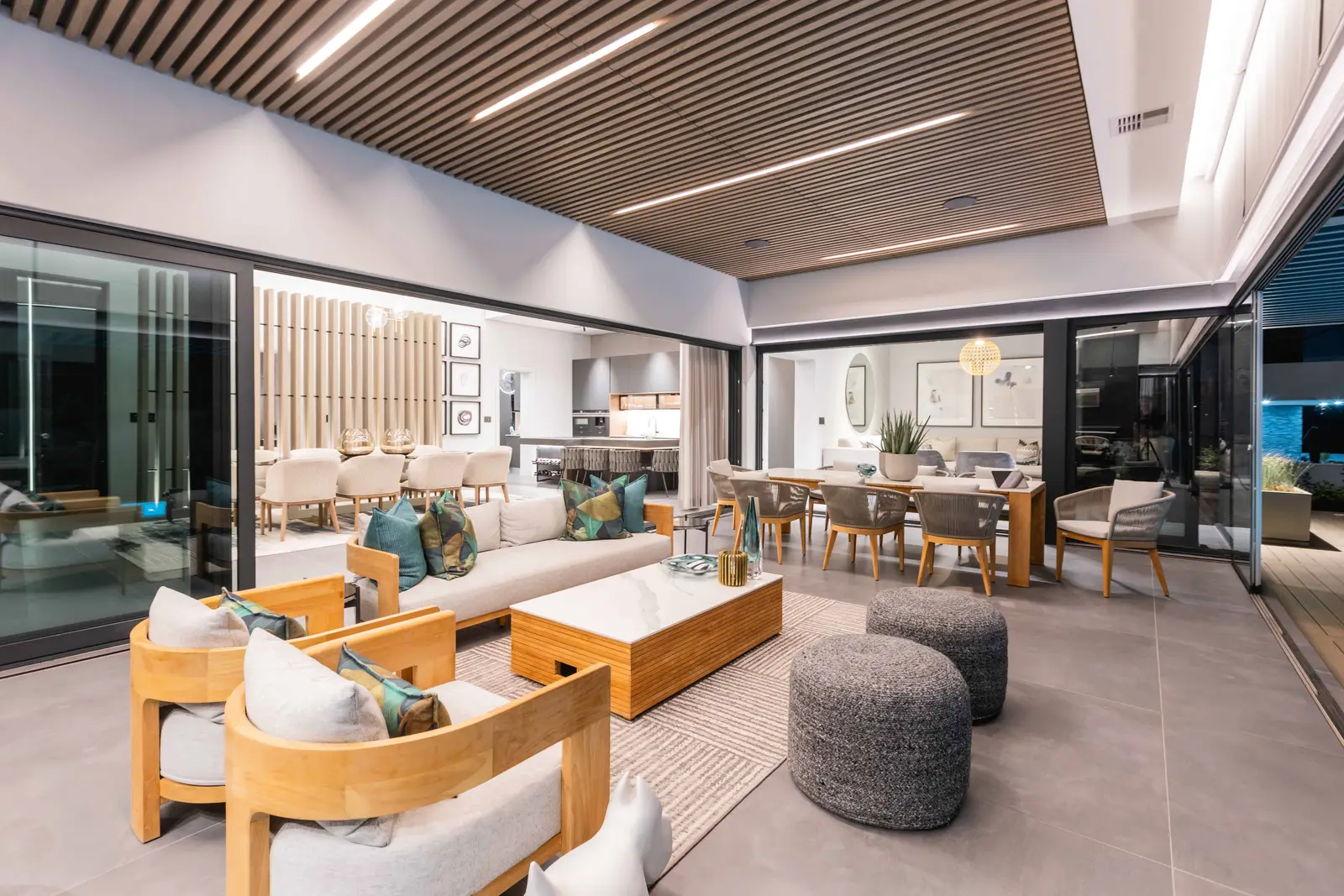 Seamless indoor-outdoor entertainment zone with lounge, dining, and covered deck in Steyn City – Johannesburg interior designer Renovatio.