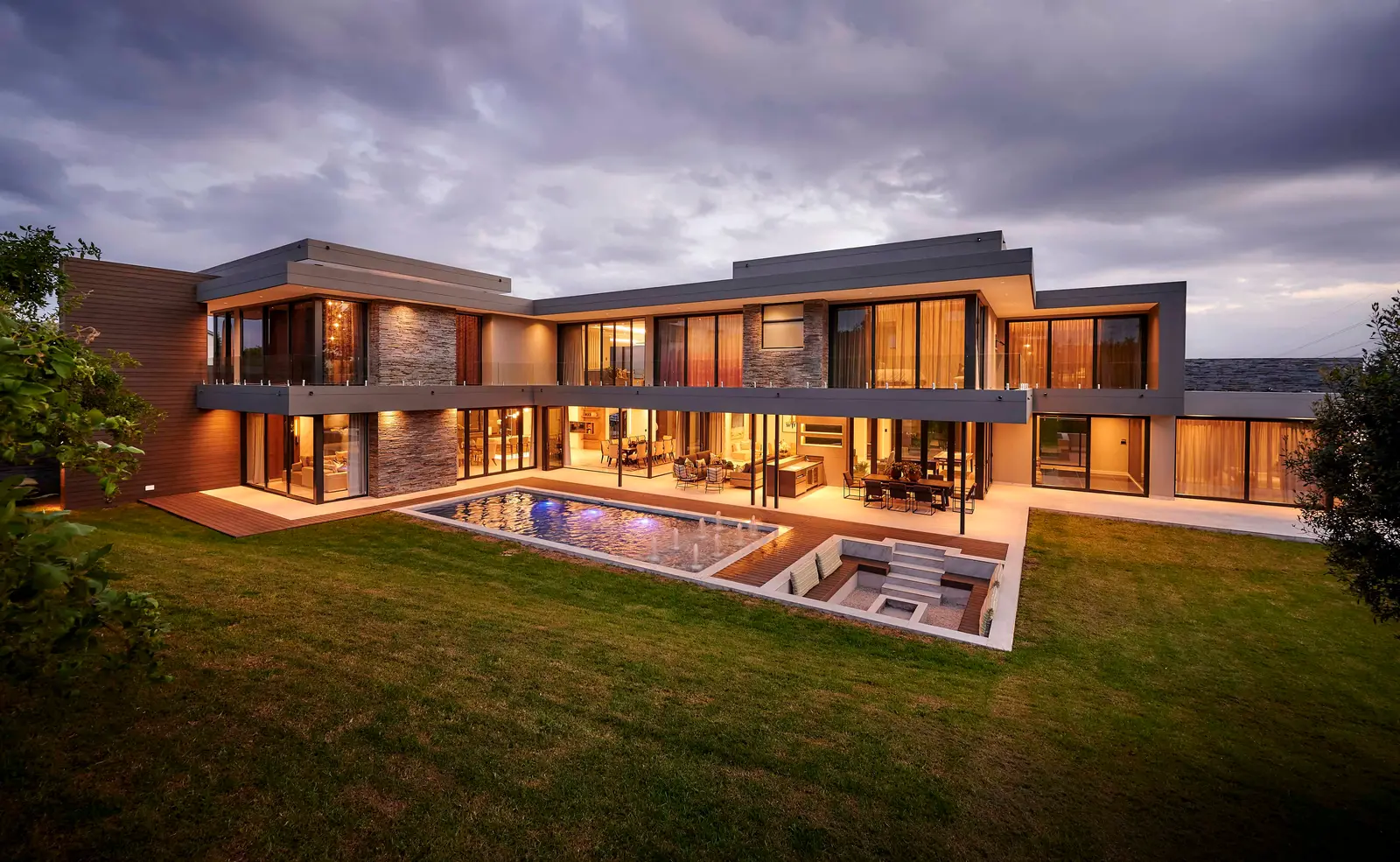 Contemporary house exterior featuring glass walls, landscaped garden and spacious terrace crafted by Interior Designer Johannesburg.
