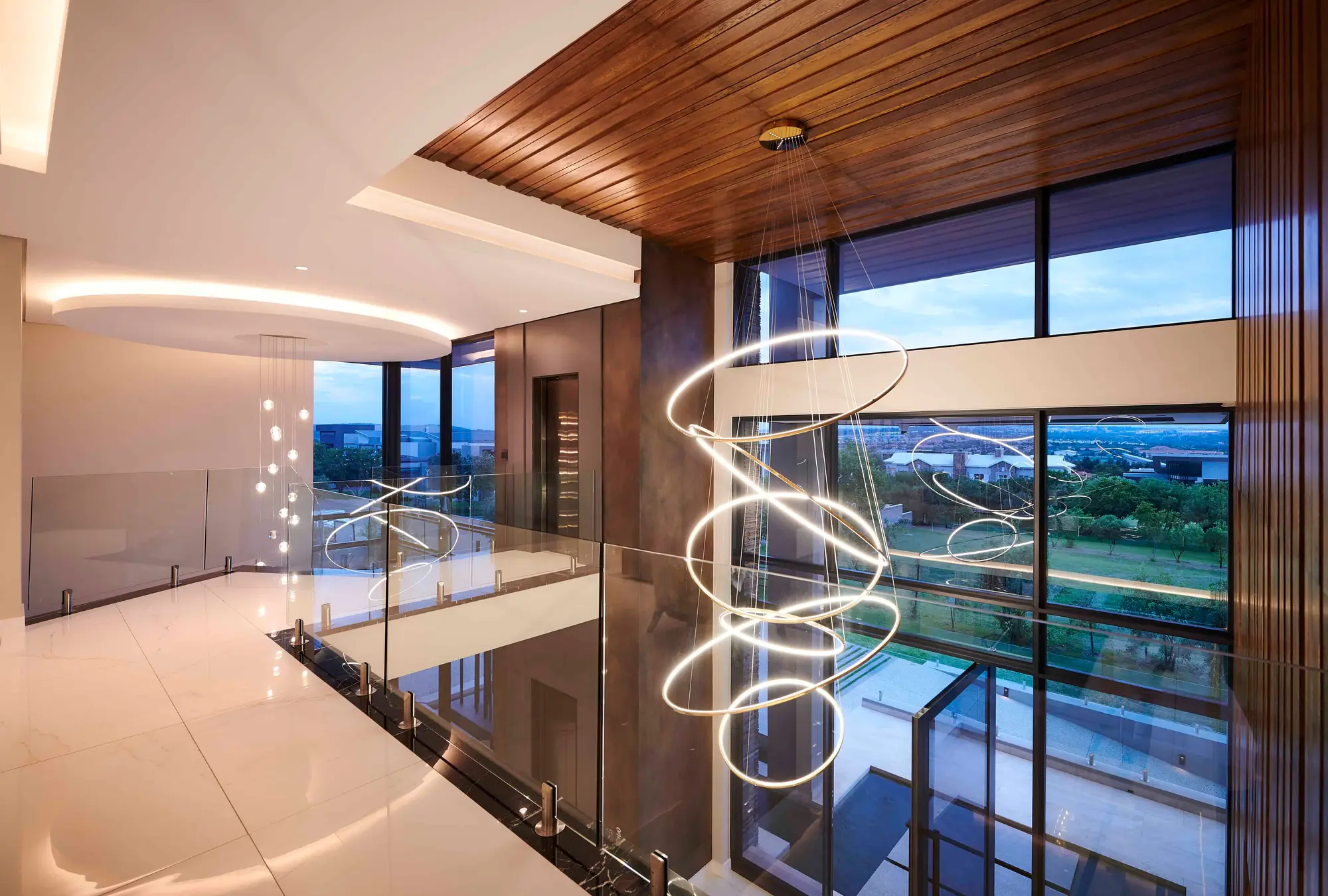 Double-volume entrance hall with sculptural chandelier and panoramic glazing, by Renovatio Interiors Johannesburg