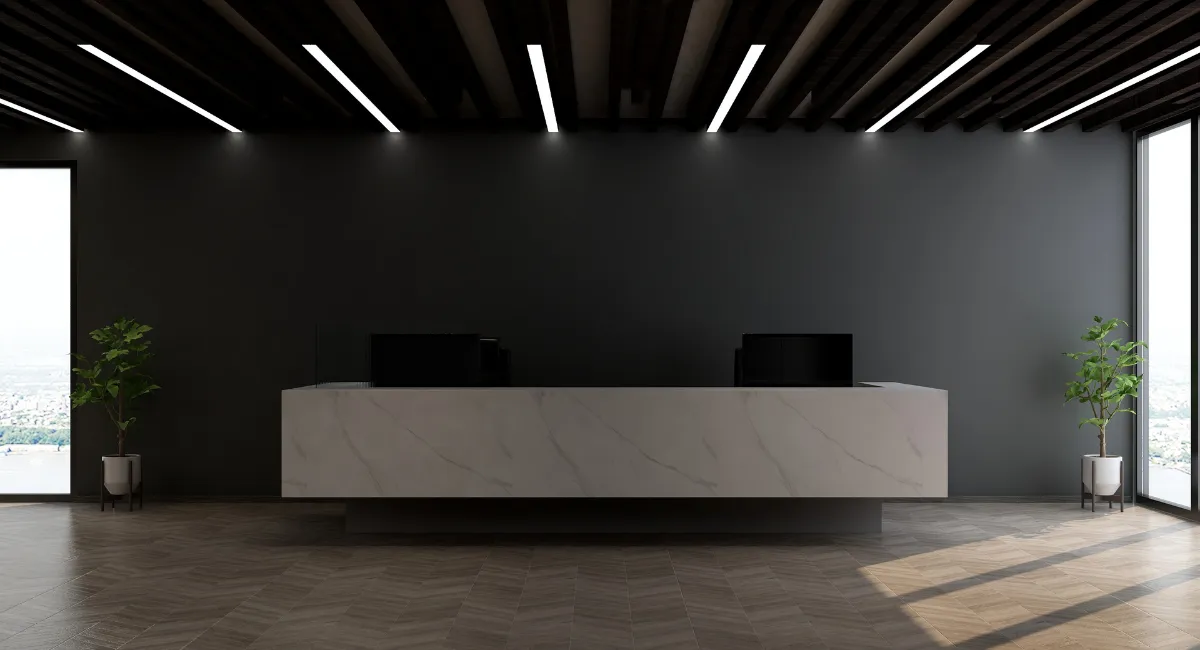 Modern reception area with sleek marble desk, wood-panel ceiling, and natural lighting — reflecting contemporary office design that enhances brand identity.